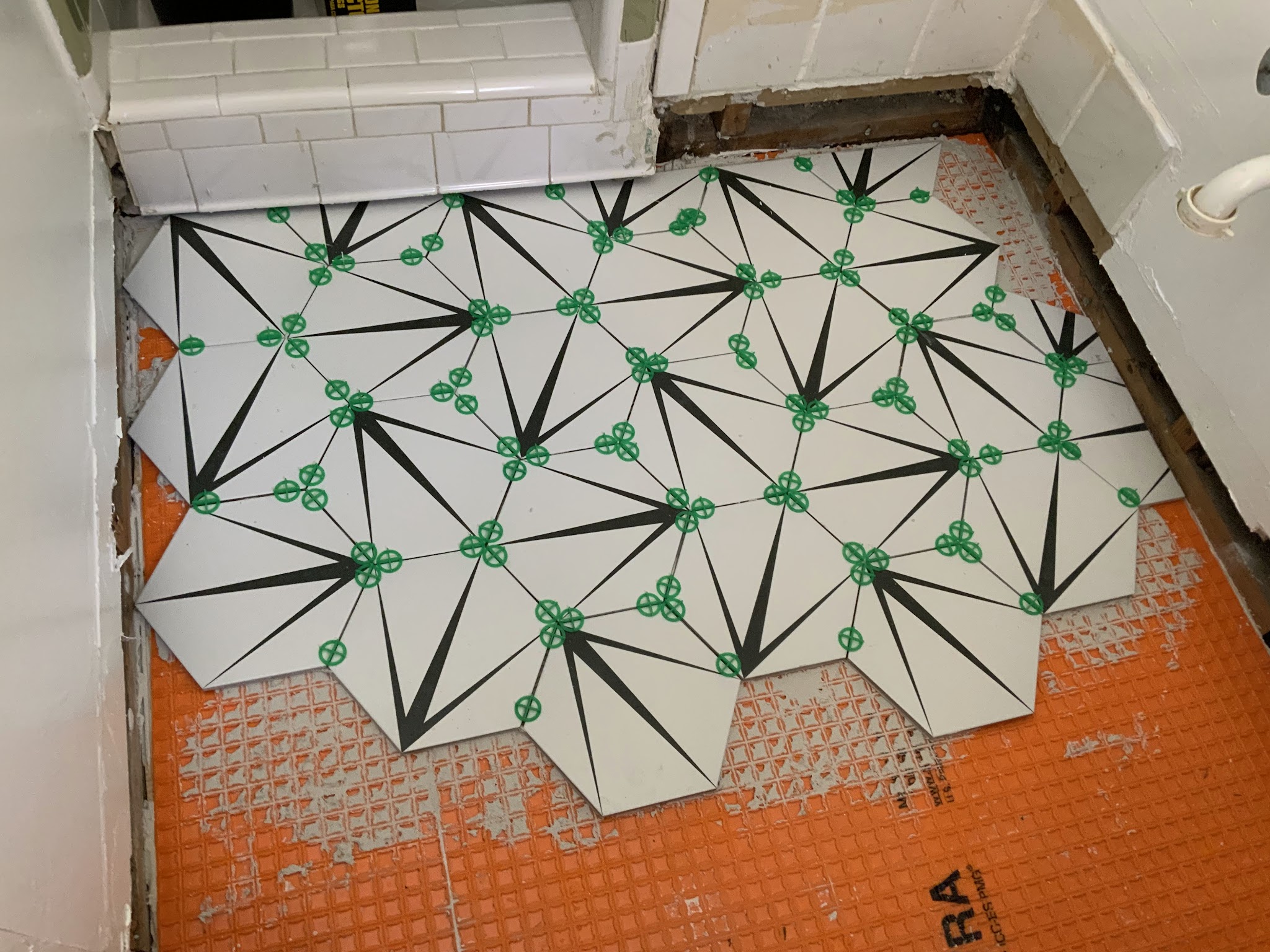 Hexagon floor tile being laid out in a bathroom