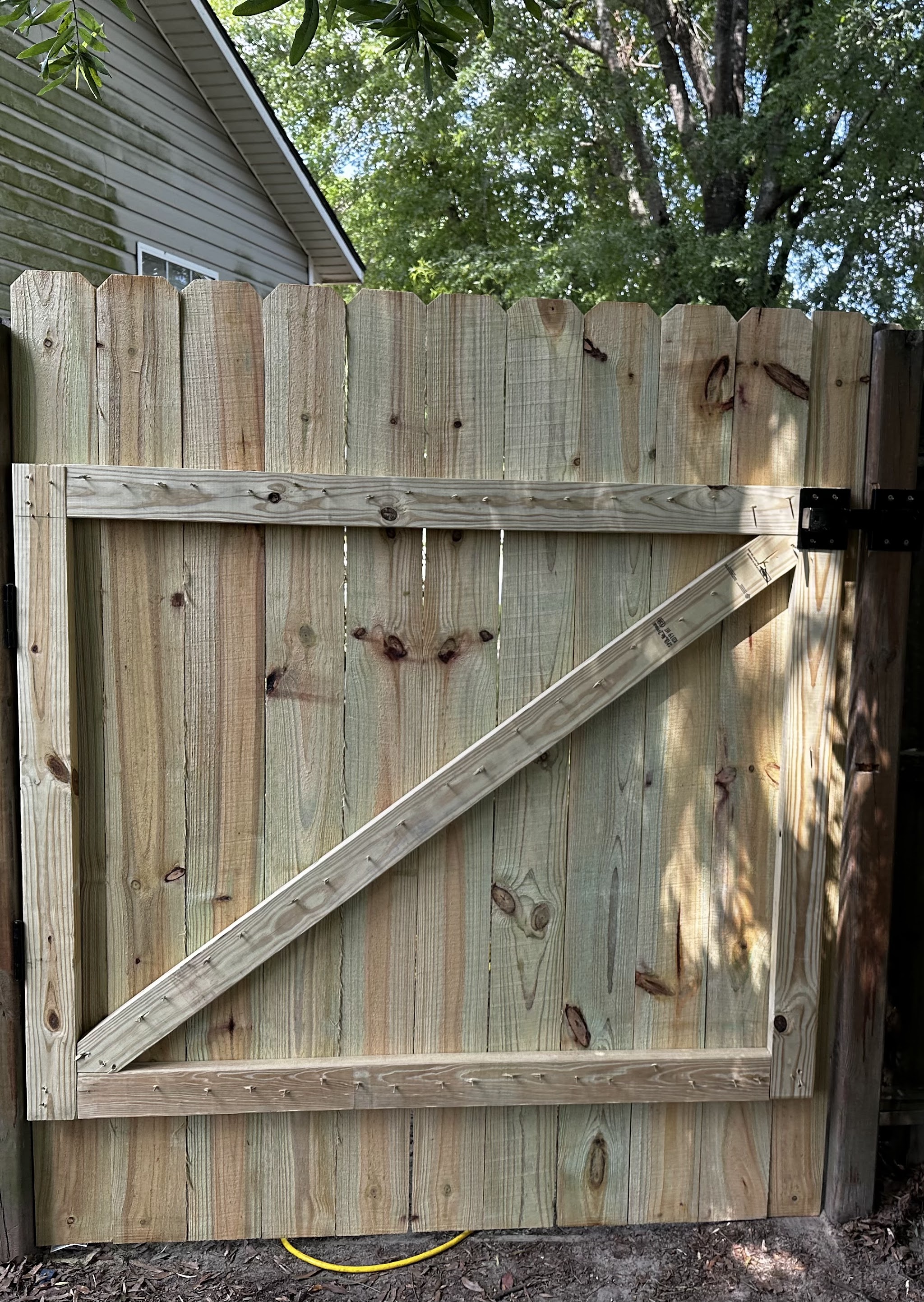 New wooden fence gate with a Z brace and black hinges