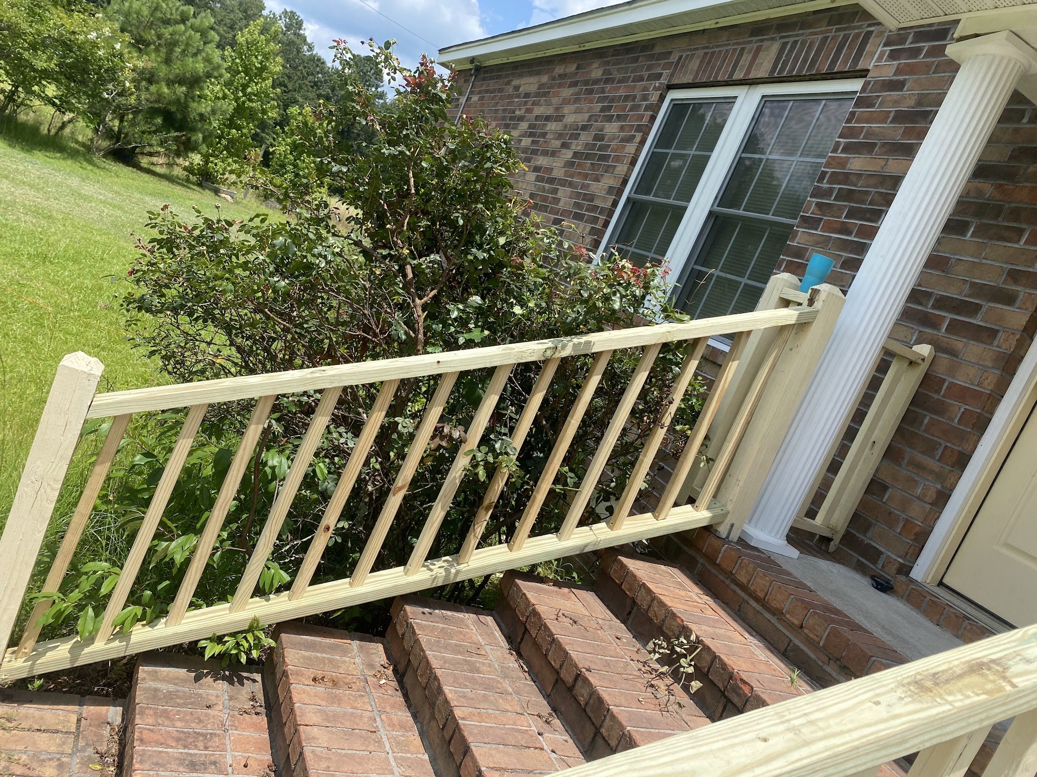 New wooden railing on brick porch steps