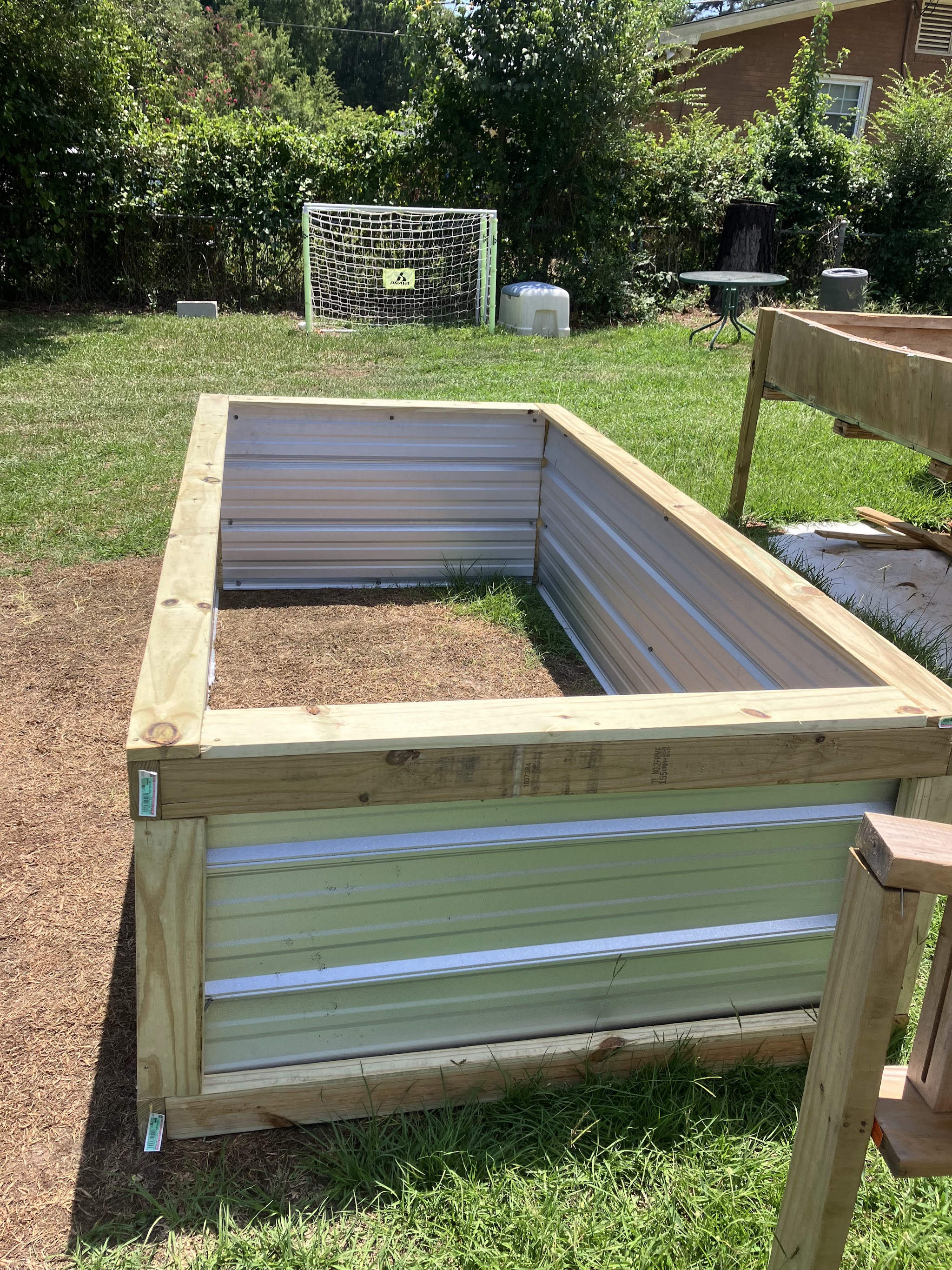 Raised garden bed built from lumber and corrugated metal